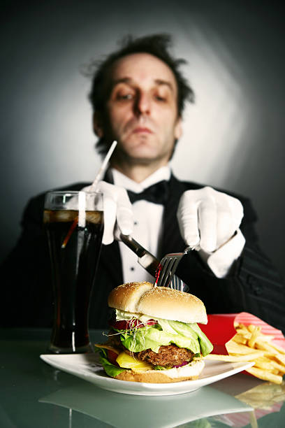 istock Man in Tuxedo Cutting Burger 108130073
