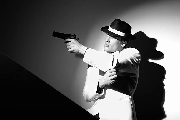 Black suits man holding semi-automatic pistol