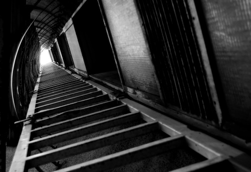 An empty stairway with orange bannister is leading up to the exit of a subway station in Vienna.\nCanon EOS 5D Mark IV, 1/4, f/10, 24 mm.