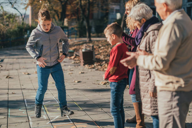 istock Multigenerational family having fun playing hopscotch 1081309068