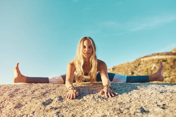 Shot of an athletic young woman practicing yoga on the beach