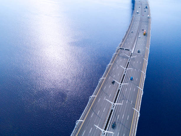 海の高速道路の空撮。車橋インターチェンジを横断陸橋します。トラフィックを高速道路のインターチェンジ。空中の鳥の目の高速道路。高速道路。道路のジャンクション。通過する車。ト� - traffic sea passage overpass car ストックフォトと画像