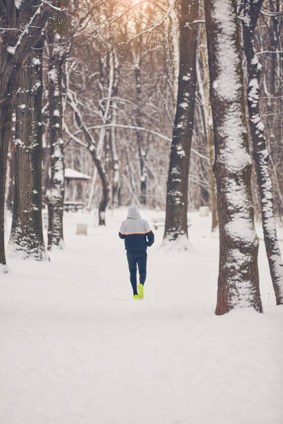 istock Man jogging in snowy park and cold weather. 1081331864