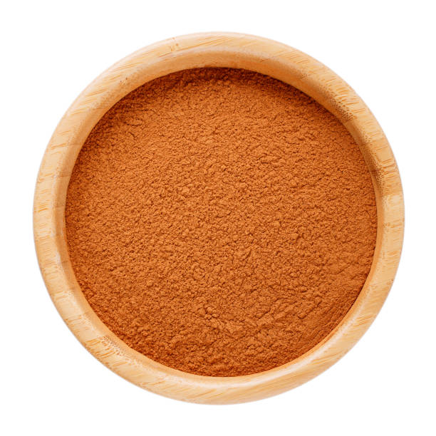 istock Ground cinnamon in wooden bowl isolated on white. Top view. 1081337284