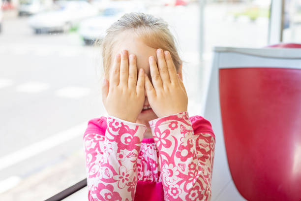 Cute asian baby girl closing her face and playing peekaboo or hide and seek with fun