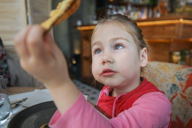 istock little girl looking at fried eggplant slice in restaurant 1081339774