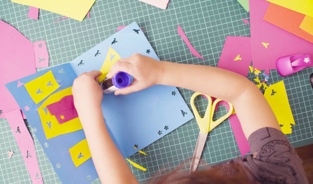 mani di bambina incollando carta colorata - card making foto e immagini stock