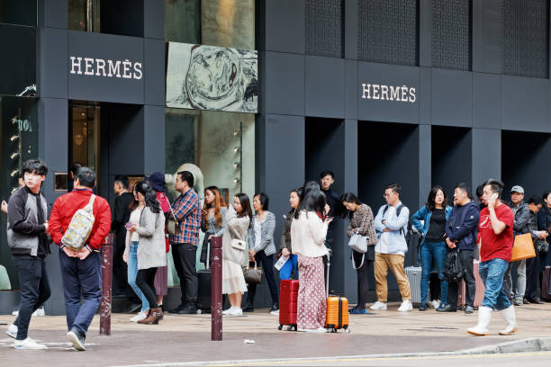 people walk past the hermes shop in canton road, hong kong. - harbour city imagens e fotografias de stock