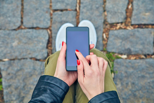istock Woman sitting on a bench and using smartphone. 1081354682