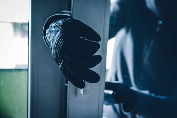 burglar breaking into house - burglary imagens e fotografias de stock