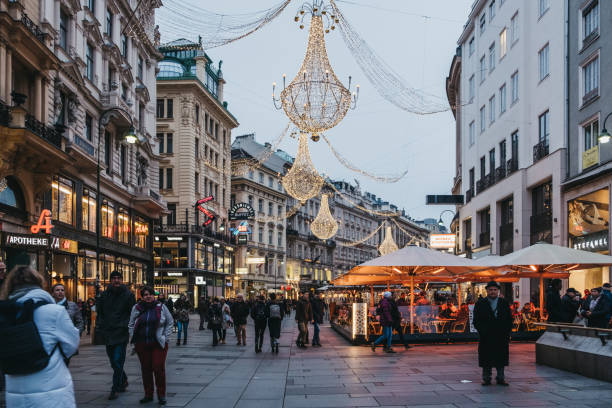 People walking under Christmas lights on Graben, Vienna, Austria. Vienna, Austria - November 24, 2018: People walking under Christmas lights on Graben, Vienna, one of the most famous streets in Vienna's first district for shopping, sightseeing and architecture. people shopping in graben street vienna austria stock pictures, royalty-free photos & images