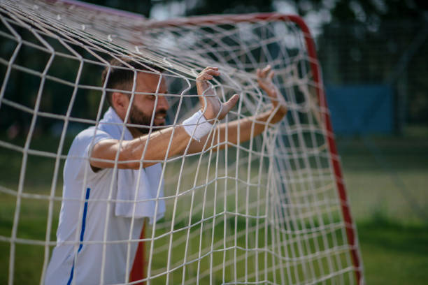 istock A handsome man resting after exercising on a football pitch 1081367440