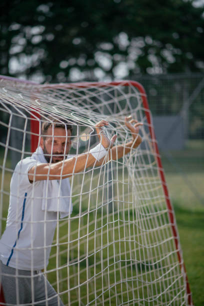 istock A handsome man resting after exercising on a football pitch 1081370748