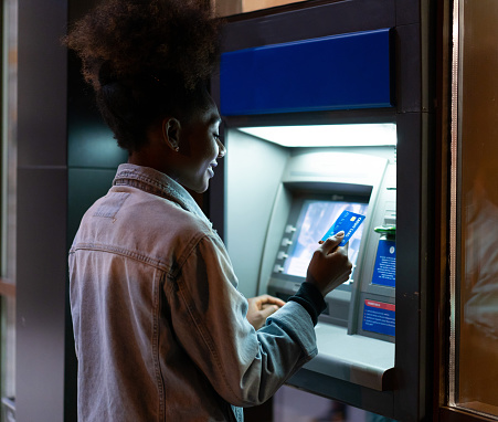 Afro American woman withdrawing money at the ATM