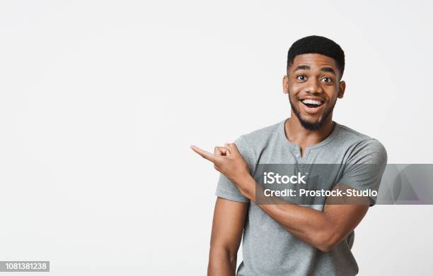 Africanamerican Man Pointing Aside At Copy Space Stock Photo - Download Image Now - Pointing, Men, Surprise