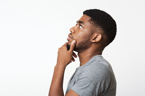 Searching for idea. Thoughtful african-american man profile portrait on white, copy space