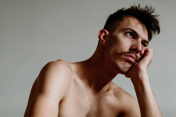 młody mężczyzna bez koszuli z wąsami myślącymi - teenager dark pensive emotional stress zdjęcia i obrazy z banku zdjęć
