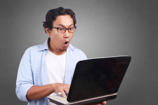 istock Young Man Playing with His Laptop, Surprised Expression 1081394158