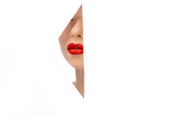 istock beautiful young woman with red lips, view through hole on white 1081396586