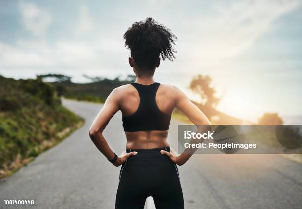 An athletic woman poses while running with a blue sports bra and black  running shorts in front of Horsetooth Reservoir. Composite. stock photo