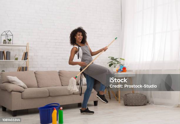 Zwarte Vrouw Luchtgitaar Spelen Met Mop Stockfoto en meer beelden van Schoonmaken - Schoonmaken, Volwassen vrouwen, Alleen één vrouw