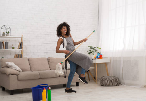 black woman playing air guitar with mop - spring cleaning women cleaning dancing imagens e fotografias de stock