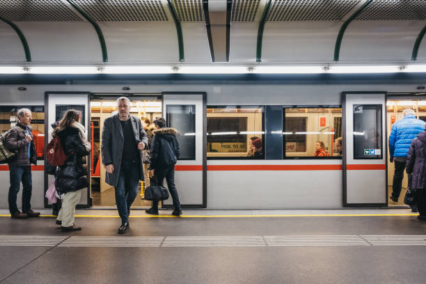 Vienna, Austria - November 25, 2018: People on the underground platform in Vienna, train with open doors on the background. Vienna public transport, Wiener Linien, operates five underground lines.