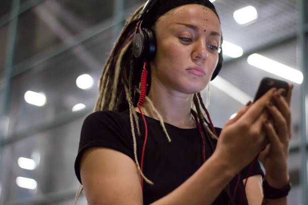 istock young woman with dreadlocks using smartphone at the airport at night. having fun 1081424196