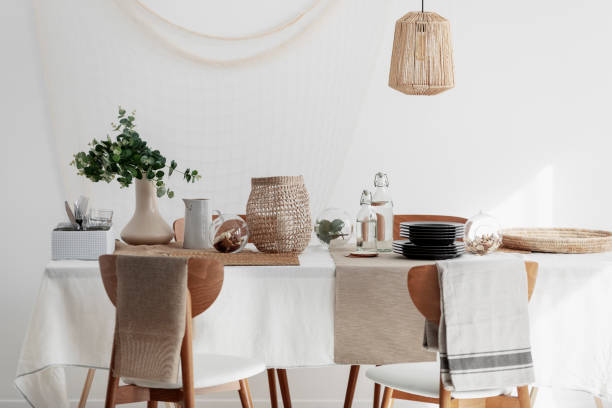 istock Natural dining room with linen napkins, white tablecloth and wicker lamp 1081428048