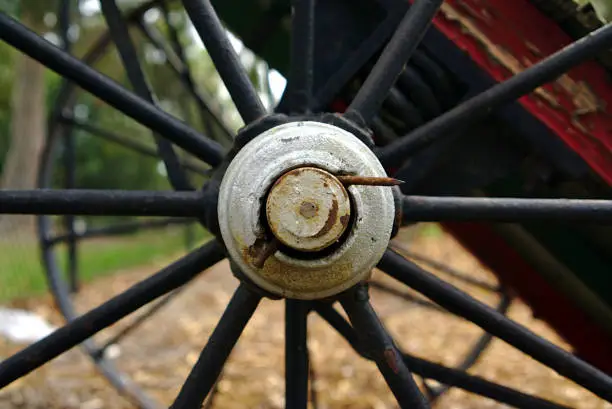 Photo of Old abandoned black metal wheel of farm machinery from 19th century