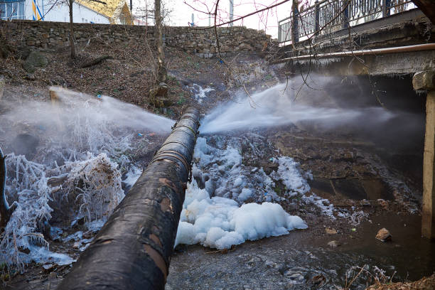 Water pressure from a large pipe over the river Water pressure from a large pipe over the river, in winter pipe smoking pipe stock pictures, royalty-free photos & images
