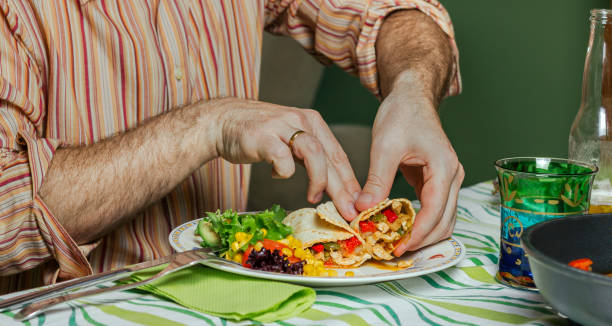 istock Man hands eating mexican food 1081446484