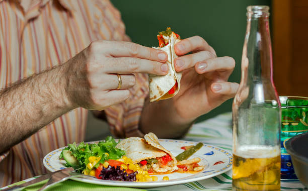 istock Man hands eating mexican food 1081446492