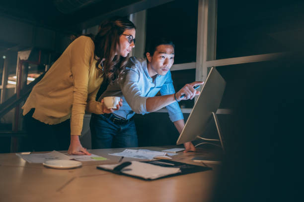 istock Business partners working together on computer late in office 1081449702
