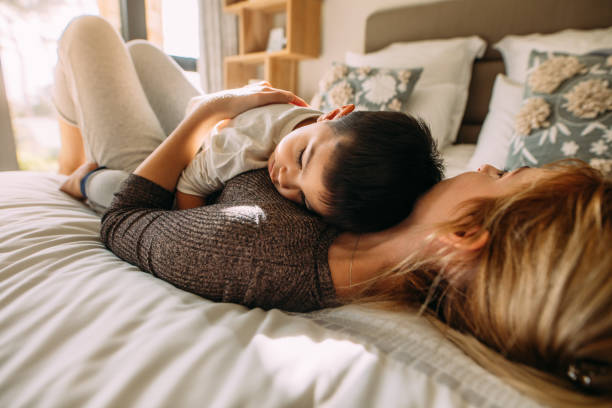 istock Mother and son sleeping together in bed 1081453442