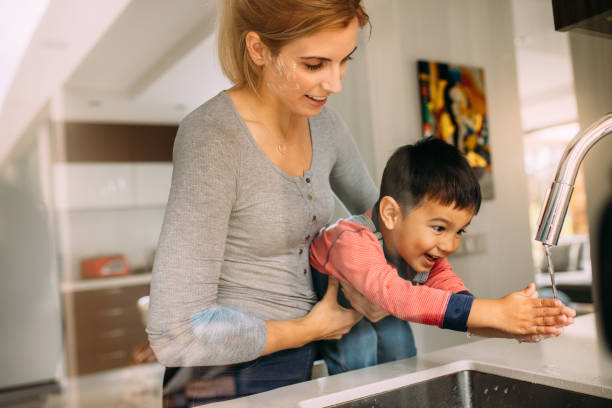 istock Mother helping son to wash hands after baking 1081453774