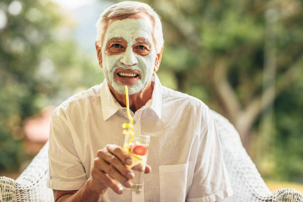 istock Fully elderly man with clay mask on face having juice 1081454092