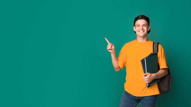 istock Teen student with books pointing on copy space 1081457268