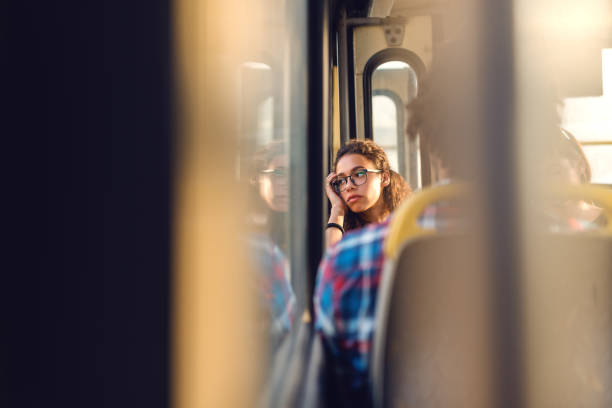 istock Thoughtful girl looking through window while sitting in public transportation. 1081457740