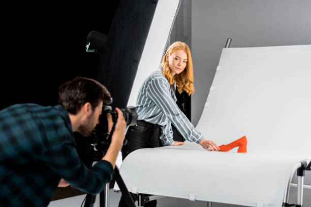 istock male photographer working with camera while colleague arranging shoe in studio 1081458866