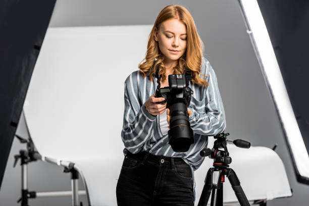 istock beautiful young woman using photo camera in studio 1081458924