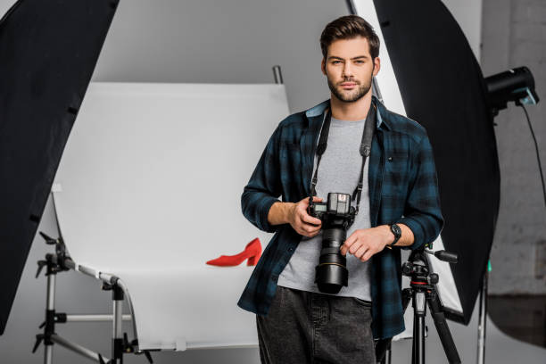 istock handsome professional young photographer looking at camera in studio 1081458946