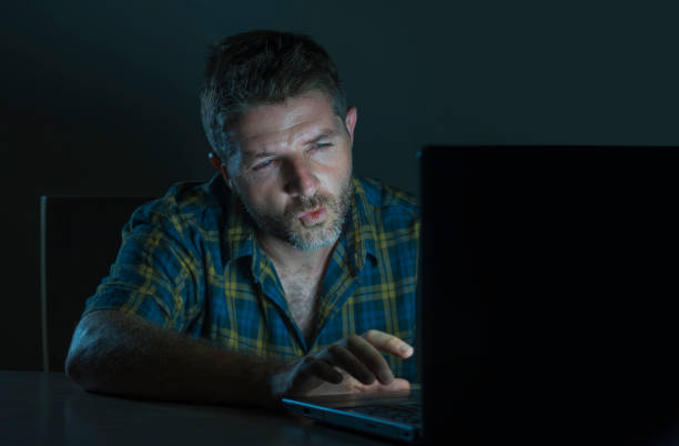 young aroused and excited sex addict man watching porn mobile online in laptop computer light night at home desk in pornography addiction and internet pornographic content concept young aroused and excited sex addict man watching porn mobile online in laptop computer light night at home desk in pornography addiction and internet pornographic content concept perv stock pictures, royalty-free photos & images