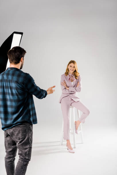 istock back view of young photographer talking with beautiful smiling female model in studio 1081475904