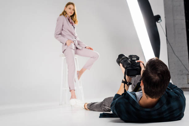 istock photographer lying and shooting beautiful female model posing in studio 1081475922