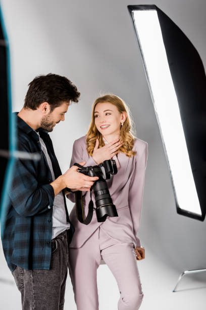 istock smiling young photographer and beautiful model checking photos on camera in studio 1081476044