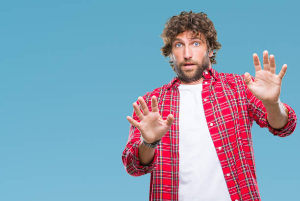 istock Handsome hispanic model man over isolated background afraid and terrified with fear expression stop gesture with hands, shouting in shock. Panic concept. 1081477836