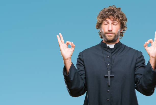 istock Handsome hispanic catholic priest man over isolated background relax and smiling with eyes closed doing meditation gesture with fingers. Yoga concept. 1081477908