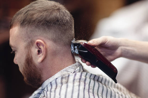 istock Barber shaves the client's head with a shaving machine. 1081480718