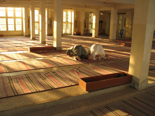 два мусульманских мужчины молиться в мечети на закате - islam india mosque praying стоковые фото и изображения